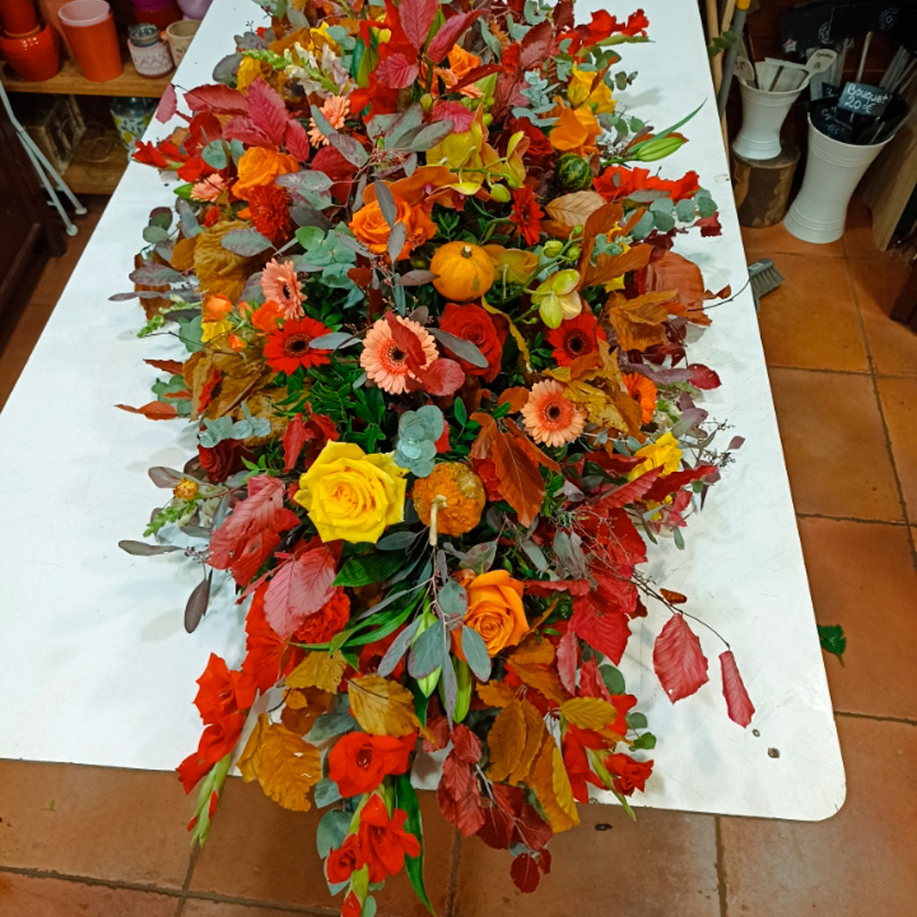 composición floral de gran tamaño en colores otoñales, con calabazas y hojas de otoño