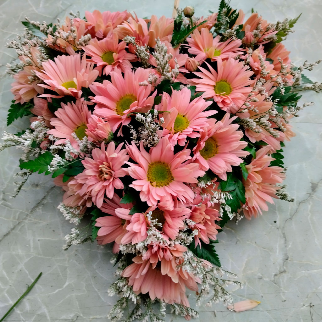 corona de flores en forma de corazón en color rosa y verde
