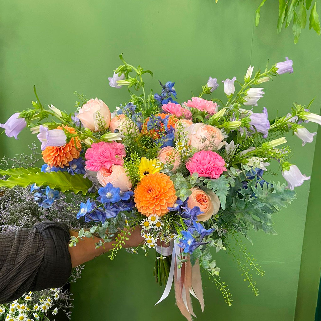 ramo de novia moderno y original con flores de colores azules y rosas mezcladas con flores silvestres