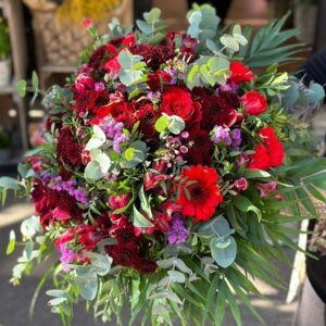 bouquet Gran Duquesa compuesto por flores en tonos rojos con un añadido en color fucsia